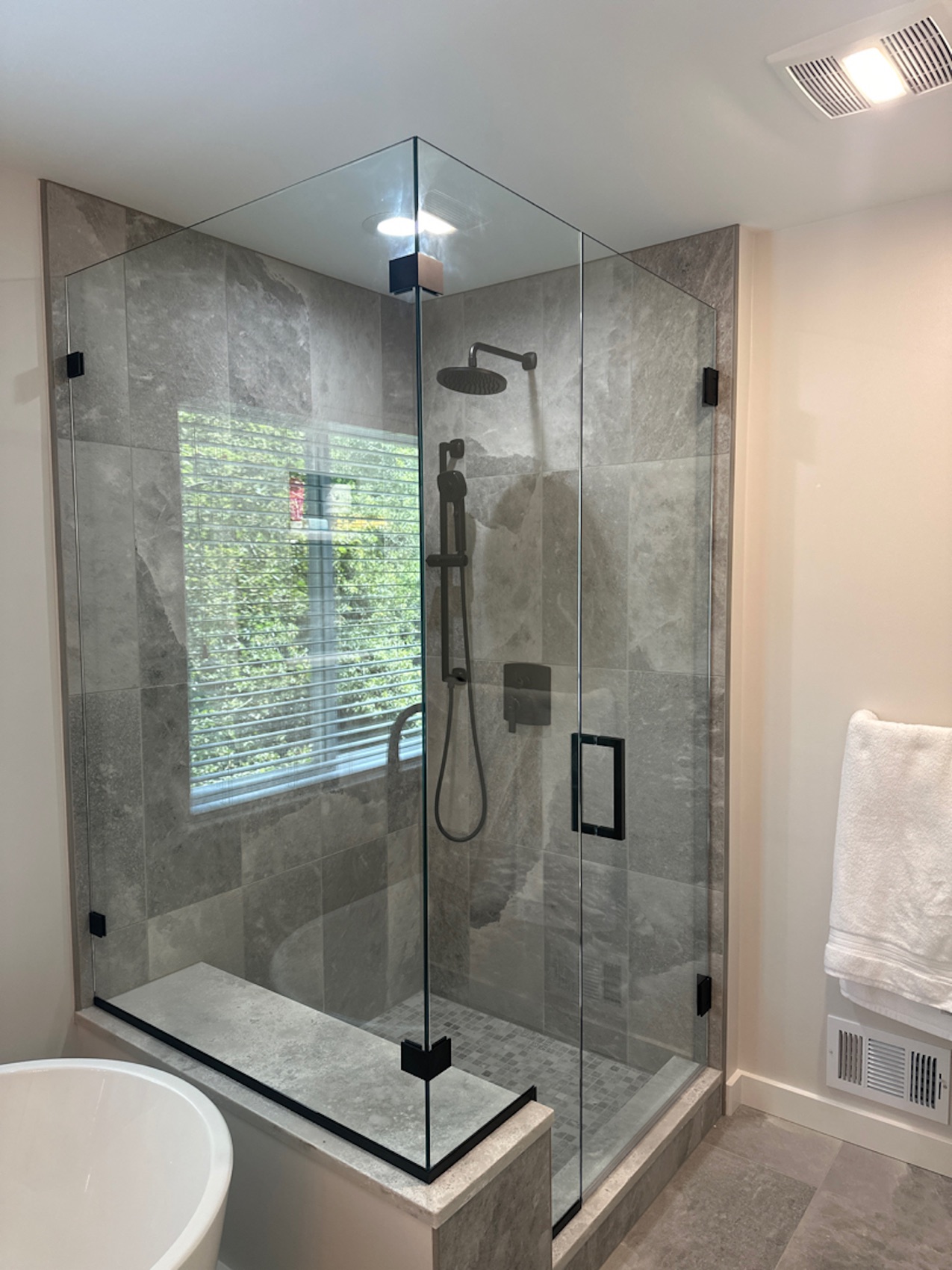Frameless corner shower enclosure with matte black hardware